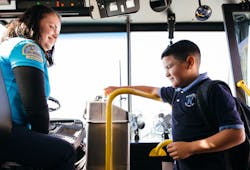 A young boy paying for fare while boarding a Santa Cruz Metro bus. A young boy paying for fare while boarding a Santa Cruz Metro bus.
