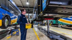 Technician operating a Stertil-Koni inground telescopic piston DIAMONDLIFT with a remote control for wheels-free lifting. Technician operating a Stertil-Koni inground telescopic piston DIAMONDLIFT with a remote control for wheels-free lifting.
