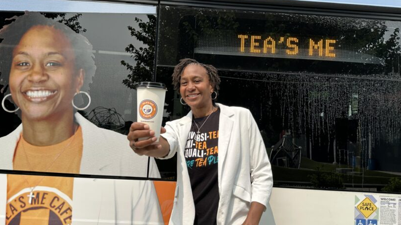 Owner/Operator of Tea&rsquo;s Me Caf&eacute; Tamika Catching posing next to the new advertisements on IndyGo buses.