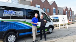 Dave Brown, general manager of MobilityTRANS, hands over the title and keys of a brand new Ford E-Transit to Fr. Tim McCabe, executive director of the Pope Francis Center. Dave Brown, general manager of MobilityTRANS, hands over the title and keys of a brand new Ford E-Transit to Fr. Tim McCabe, executive director of the Pope Francis Center.