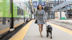 A woman with a service dog alongside a platform. A woman with a service dog alongside a platform.