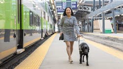 A woman with a service dog alongside a platform.