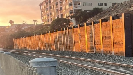 The wall built to protect the rail line below the Casa Romantica slope.