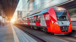 An electric passenger train drives at high speed among urban landscape. An electric passenger train drives at high speed among urban landscape.