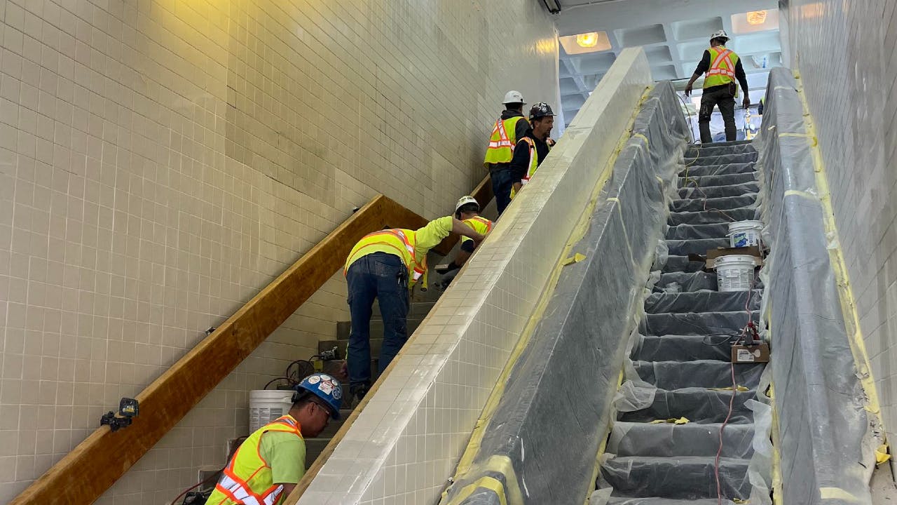 Crews performing in-station work on the stairway areas at JFK/UMass station.