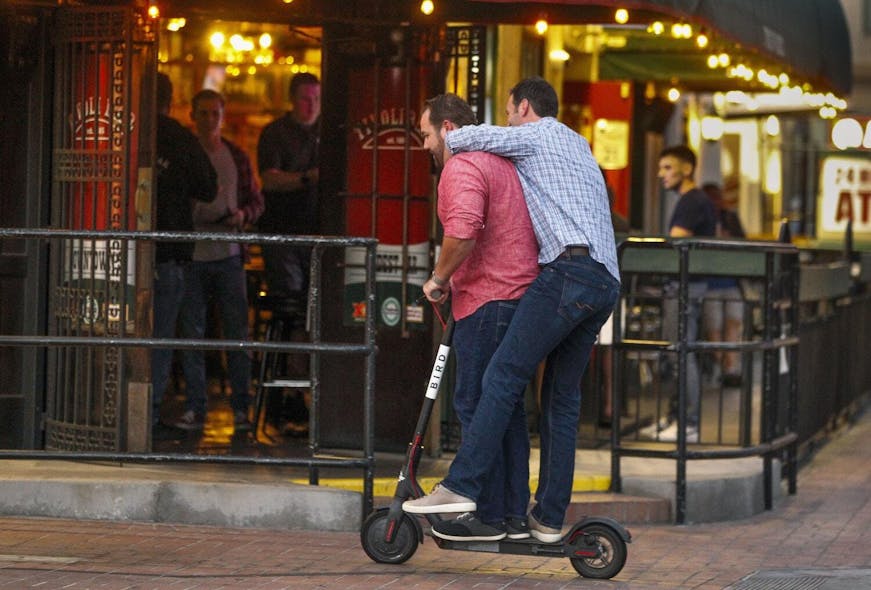Hayne Palmour IV U-T FILE Two men share an electric scooter in San Diego&apos;s Gaslamp Quarter in May. The city is considering a curfew for the vehicles.