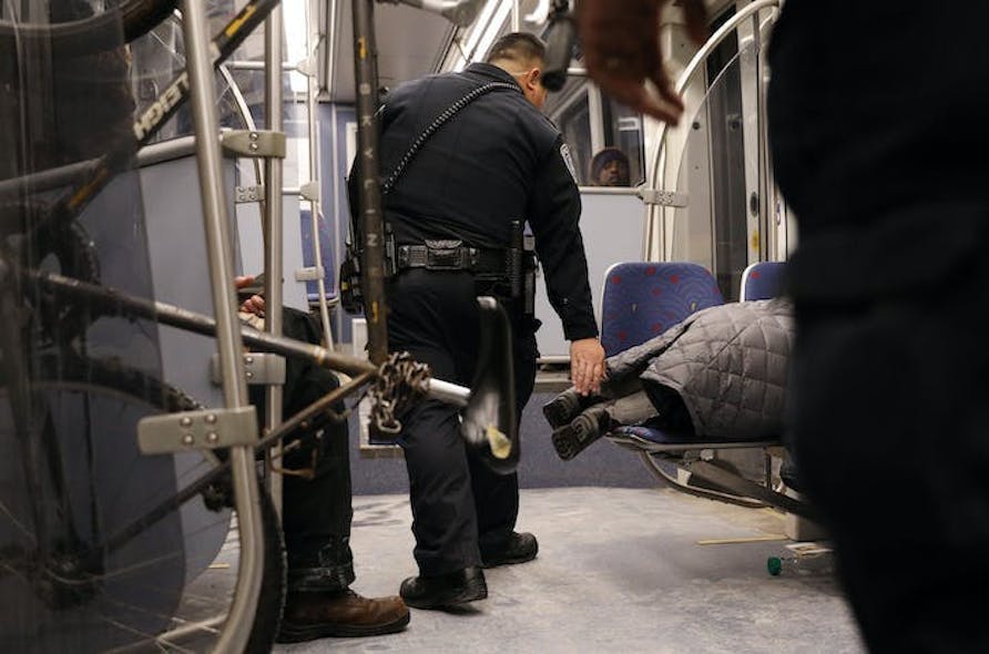 Metro Transit police wake a woman who was sleeping across two seats at night on a light-rail train, Dec. 22, 2016 in Minneapolis.