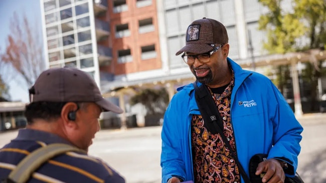 A Metro Ambassador interacts with a transit rider on April 27, 2023.