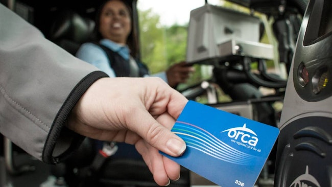 A woman hand-swiping an ORCA LIFT card.