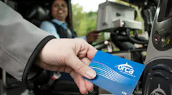 A woman hand-swiping an ORCA LIFT card.