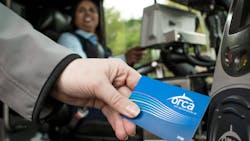 A woman hand-swiping an ORCA LIFT card. A woman hand-swiping an ORCA LIFT card.