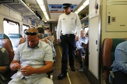 Scott Kooi collects fares on an eastbound South Shore Line train from the Millennium Park station in Chicago, Sept. 8, 2017.