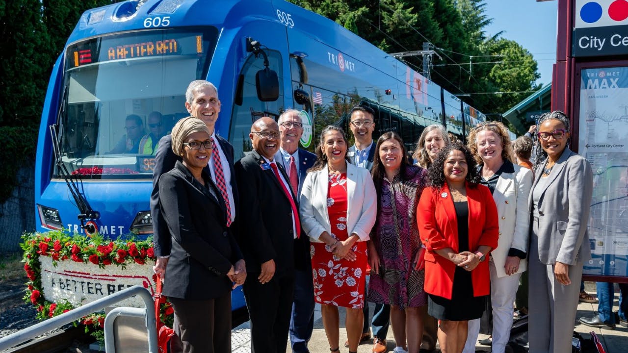 A Better Red official opening ceremony participants get ready for a ceremonial &lsquo;first ride&rsquo; on a brand new MAX train, one of four purchased as part of the project. From left to right: Washington County Commissioner Nafisa Fai, Port of Portland Chief Public Affairs Officer Dave Robertson, TriMet General Manager Sam Desue Jr., Hillsboro Mayor Steve Callaway, FTA Acting Administrator Veronica Vanterpool, TriMet Board Vice President Thomas Kim, Beaverton Mayor Lacey Beaty, Oregon Department of Transportation Public Transportation Division Administrator Suzanne Carlson, Centro Cultural Policy Director Nansi Lopez, Westside Economic Alliance Executive Director Elizabeth Mazzara Myers, PBOT Director Millicent Williams.