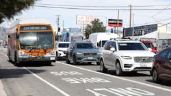 A bus in a bus lane next to cars on a freeway A bus in a bus lane next to cars on a freeway