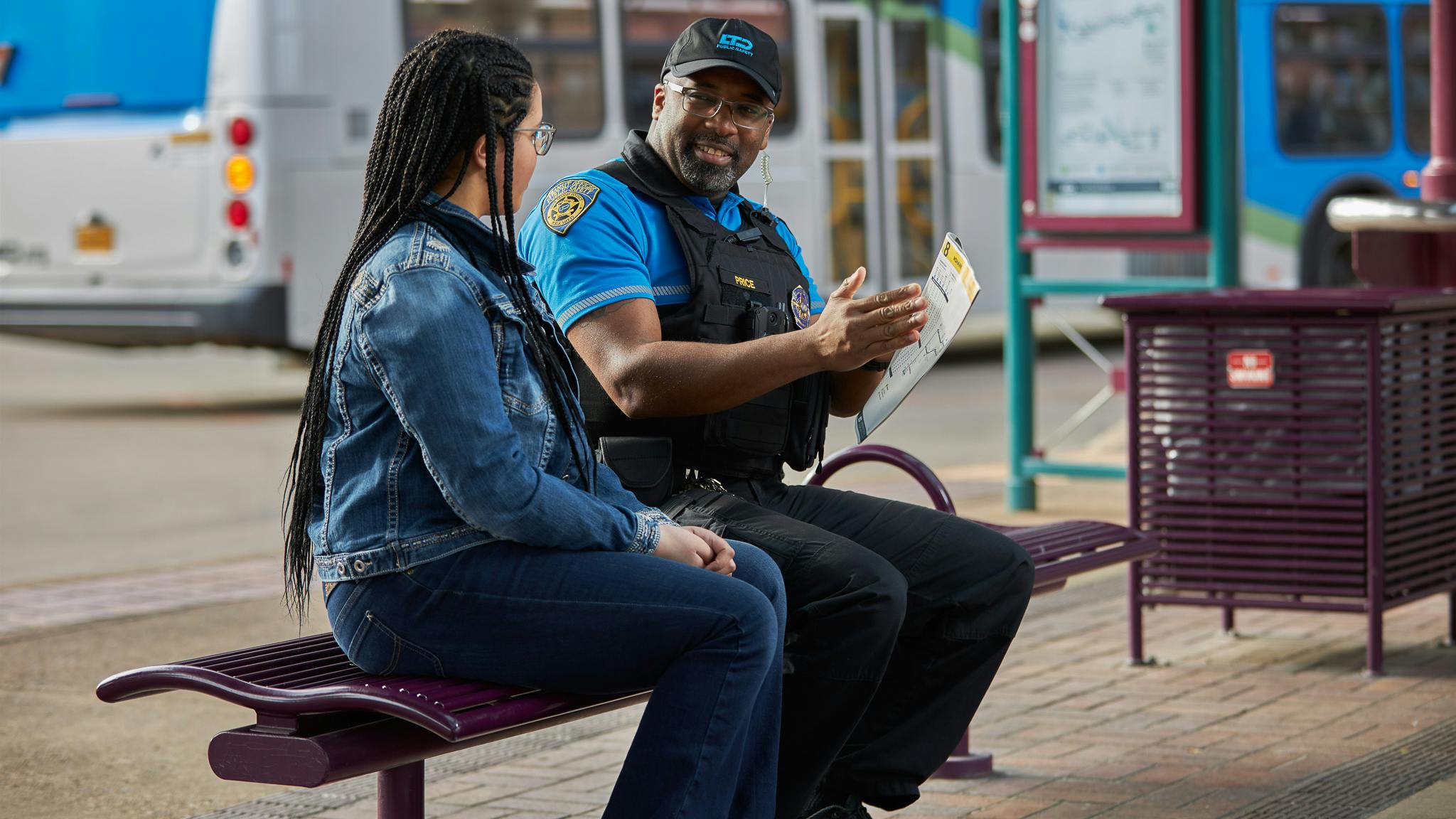 public safety officer sits with rider on bench