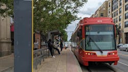 a red light rail vehicle waits at an outdoor station a red light rail vehicle waits at an outdoor station