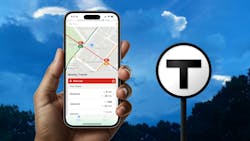 a hand hols an iphone showing vehicle tracking on the screen with the T logo in the background a hand hols an iphone showing vehicle tracking on the screen with the T logo in the background