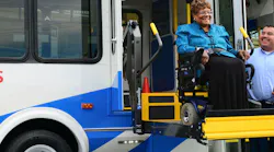 SamTrans paratransit bus operator and a rider in a wheelchair on a bus ramp.