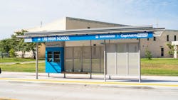 Blue CapMetro bus shelter with built in bench outside of high school Blue CapMetro bus shelter with built in bench outside of high school