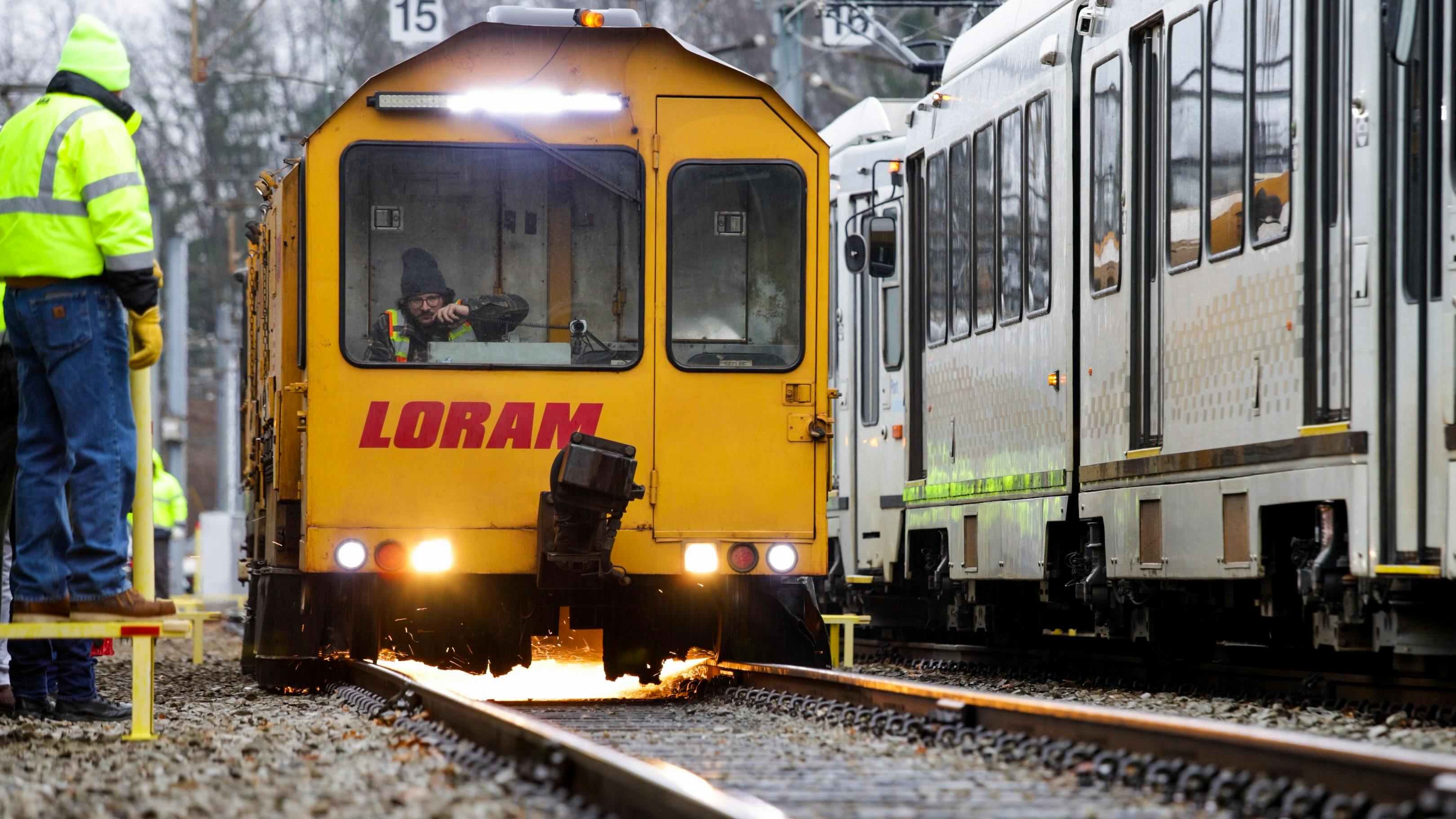 a yellow loram rail grinder operates on track
