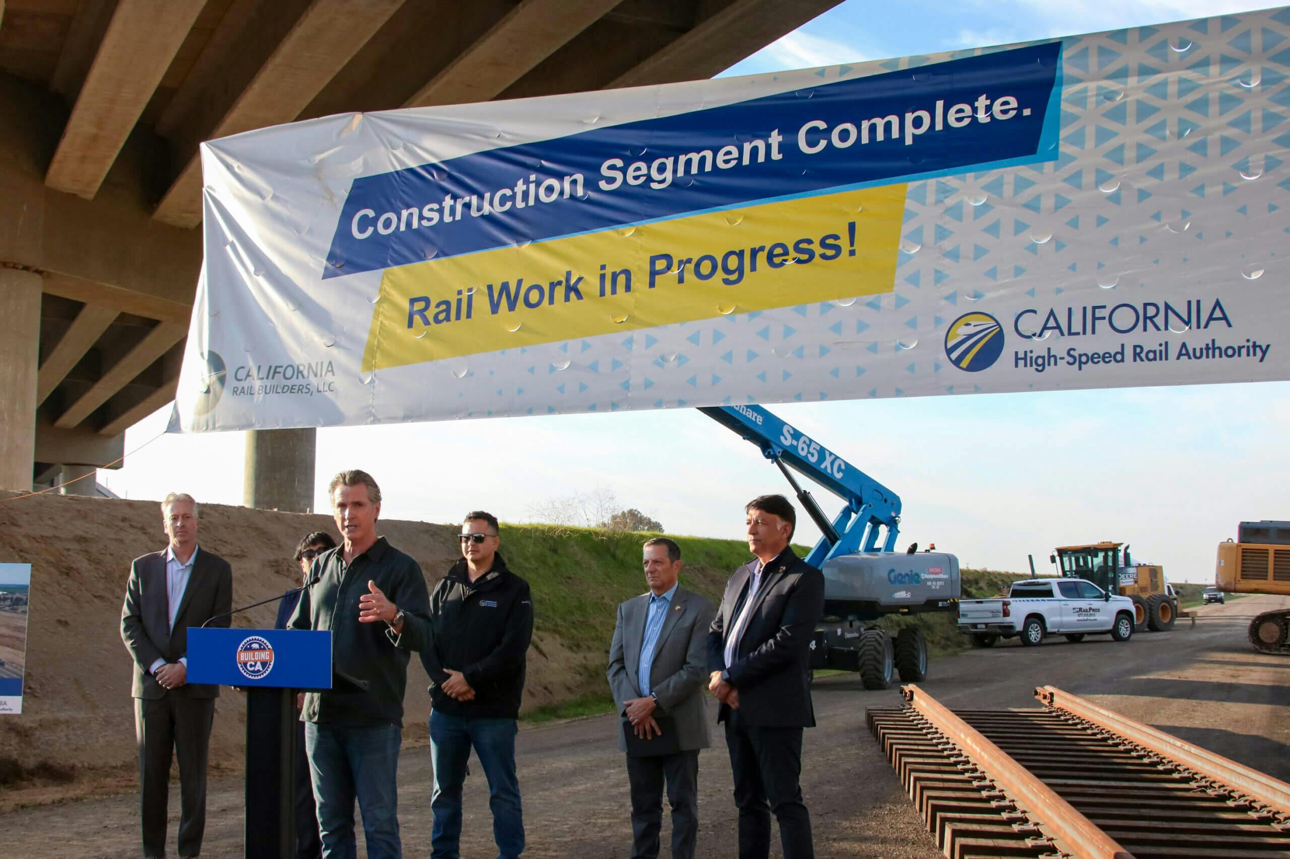 California Governor Newsom makes announcement at podium with project banner in the background