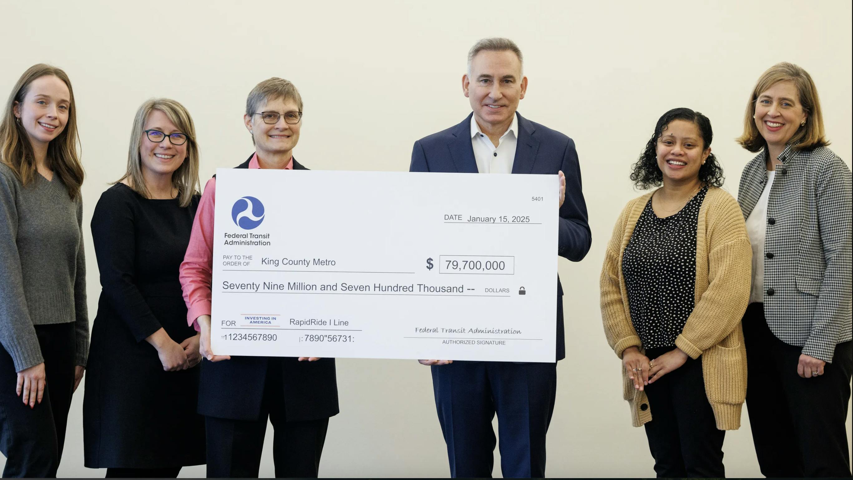 FTA Region 10 Administrator poses with king county executive holding big check