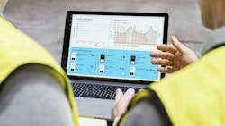 two people stand with backs to camera looking at laptop screen with charts two people stand with backs to camera looking at laptop screen with charts