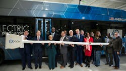 officials stand with giant plug in in front of Pace electric bus officials stand with giant plug in in front of Pace electric bus