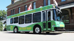 a green and white wrapped bus from T3 Transit sits on the street