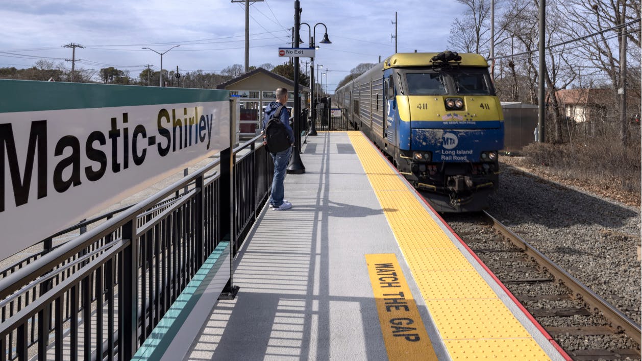 MTA LIRR Mastic-Shirley station with LIRR train pulling into renovated station