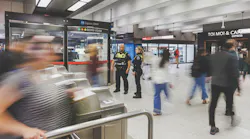 two officers stand outside fare gates in a STM's Metro station