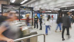 two officers stand outside fare gates in a STM's Metro station two officers stand outside fare gates in a STM's Metro station