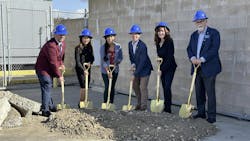 People stand in a line with shovels in a pile of dirt and blue hard hats on heads People stand in a line with shovels in a pile of dirt and blue hard hats on heads