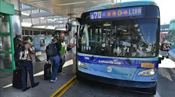MTA Q70 blue bus waits outside terminal at LaGuardia for passengers to board