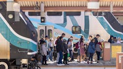 people exit a Metrolink train onto a station platform people exit a Metrolink train onto a station platform