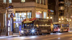 COTA bus drives down street in town center at night