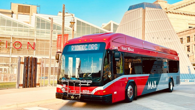 a red MAX-branded pulls out in front of a building in downtown