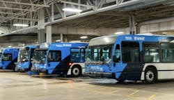 a row of saskatoon transit-branded buses parked in bus garage a row of saskatoon transit-branded buses parked in bus garage