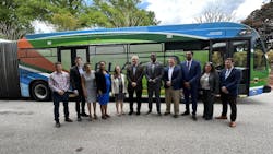line of people stand in front of parked articulated bus line of people stand in front of parked articulated bus