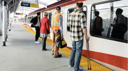 people wait to board a CTrain on a platform