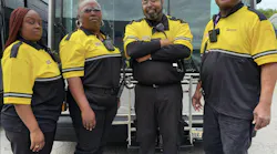 four public safety ambassadors in black and yellow uniform stand in front of GRTC bus