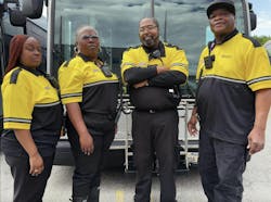 four public safety ambassadors in black and yellow uniform stand in front of GRTC bus four public safety ambassadors in black and yellow uniform stand in front of GRTC bus