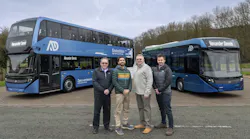 four men pose in front of a blue double decker and 40 foot alexander dennis buses
