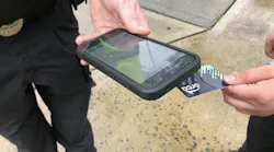 person taps their orca card with a fare enforcement officer's validator