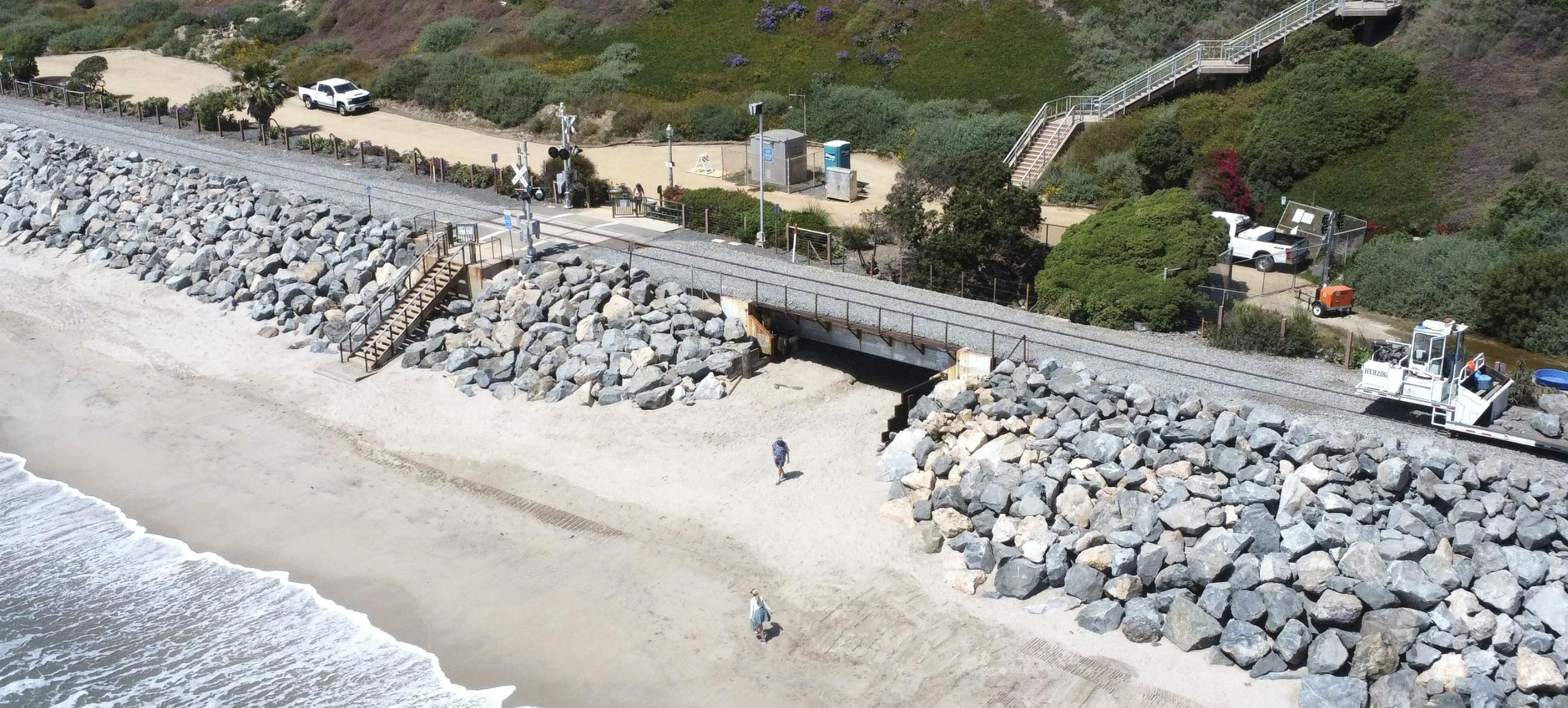 rail tracks running through san clemente near the beach showing large boulders placed along the edige