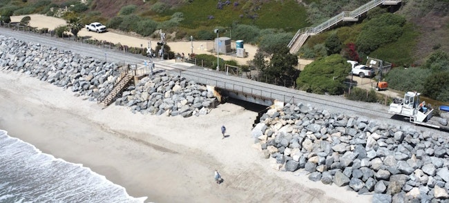 rail tracks running through san clemente near the beach showing large boulders placed along the edige