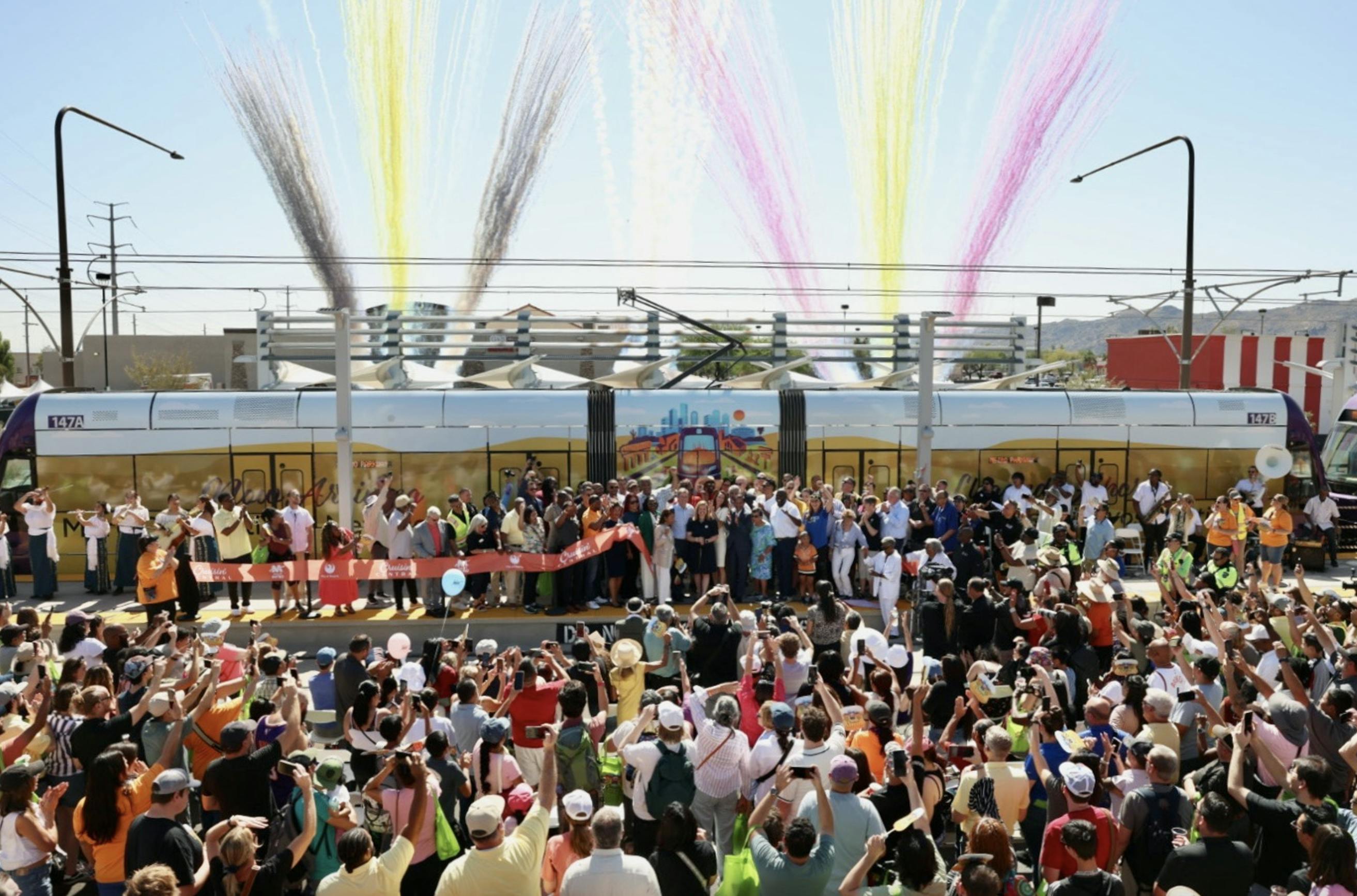 crowd gathers in front of valley metro light-rail vehicle