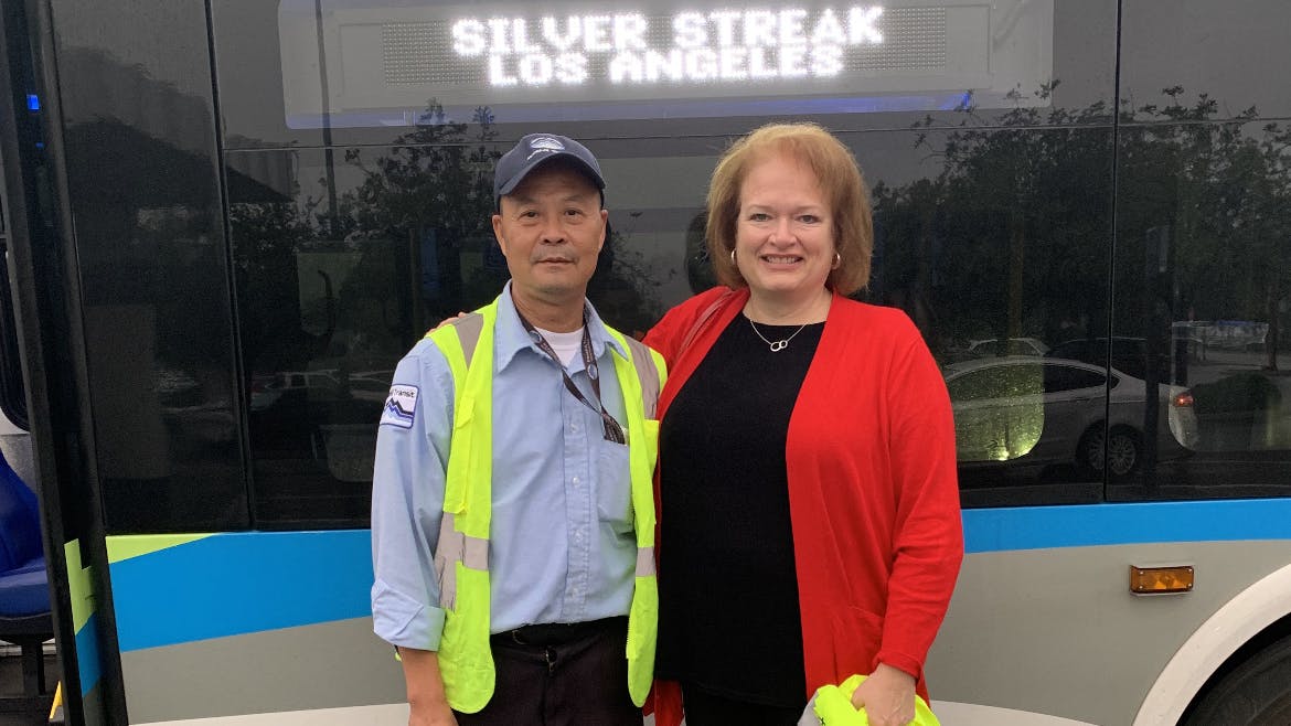 Susan Sweat poses in front of Foothill Transit bus with a bus operator