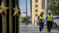 two people in safety vests and work hats mark pavement in downtown Austin two people in safety vests and work hats mark pavement in downtown Austin