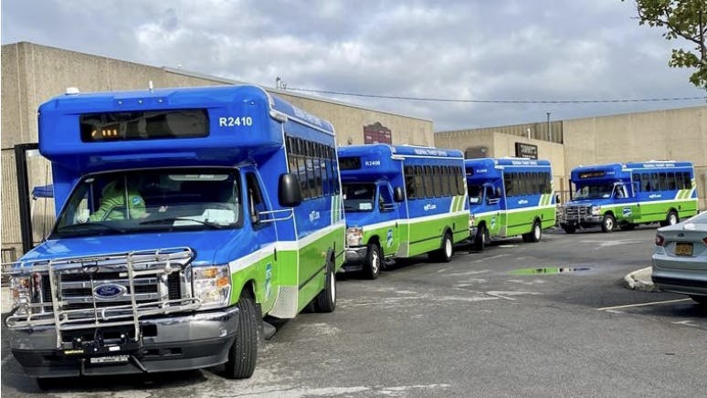 cutaway buses in RTS colors of blue and green line up at Batavia City Center hub